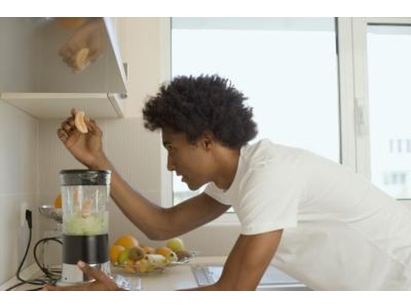 Man putting fruit in blender