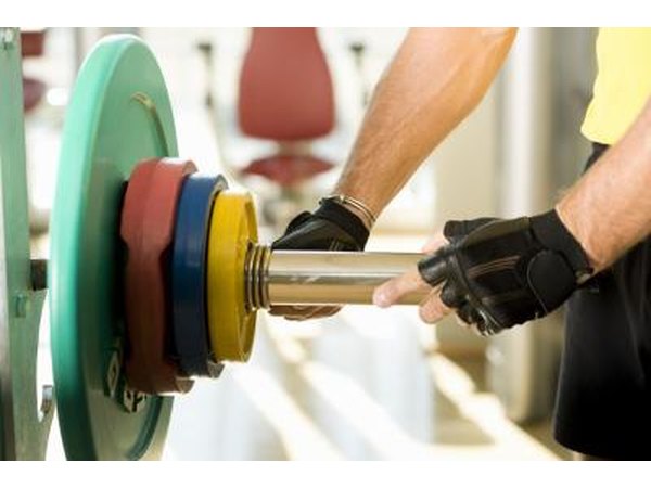A man adds weight to a barbell.