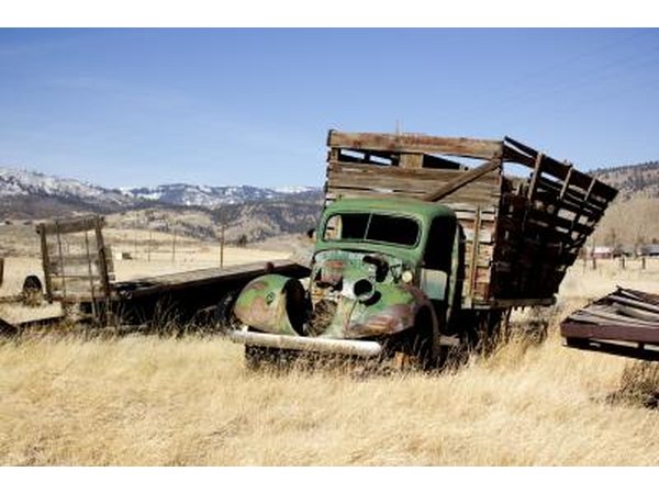 An old abandoned farm truck in a field.