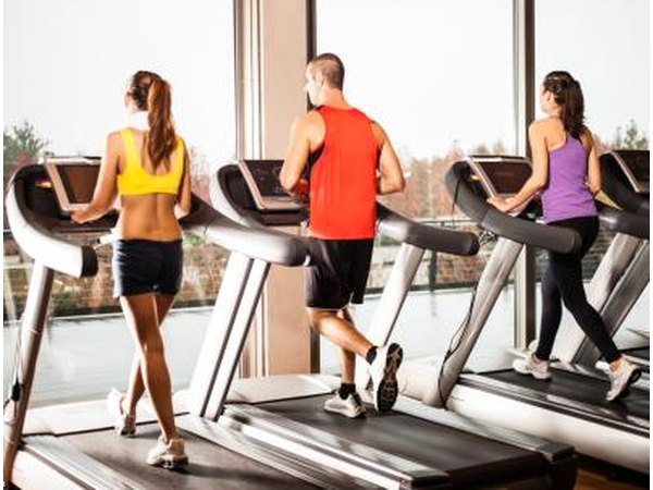 Gym members exercising on treadmills
