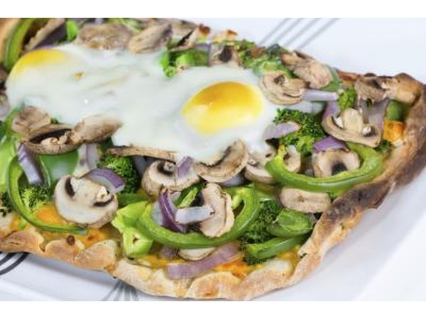 Vegetarian pizza on flat bread with two sunny side-up eggs