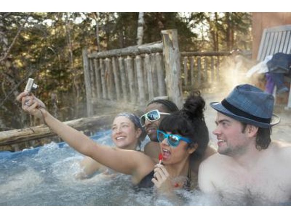 Friends taking photos in hot tub