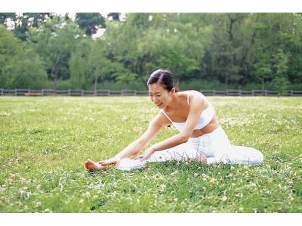 A woman stretches in a park.
