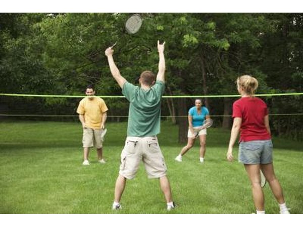 A badminton player raises his arms with excitement.