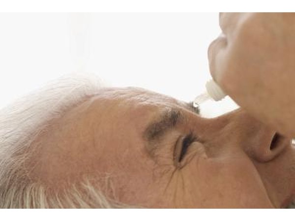 man using eye drops