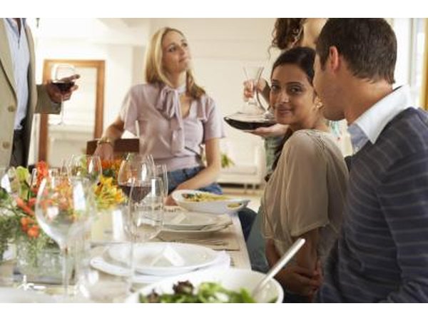 Women in casual dress at a party drinking wine.