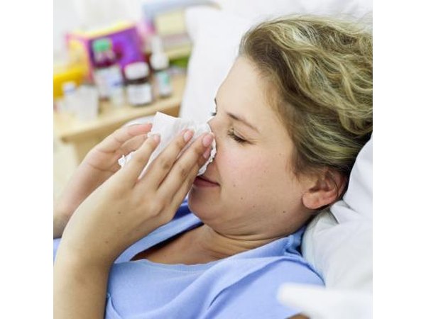 Young woman lying back with nosebleed