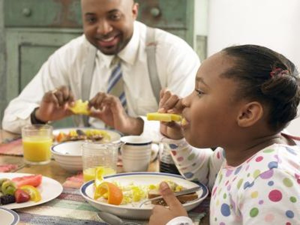 A father and daughter eating a healthy breakfast together.
