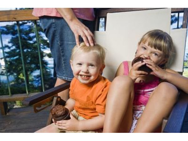 Toddler eating cupcake at party