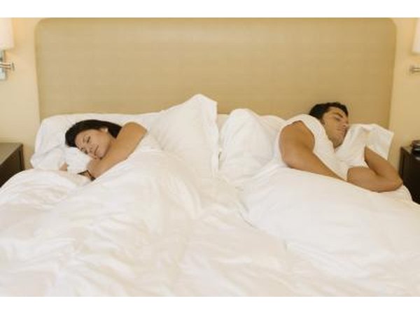 man and woman facing away from each other in bed