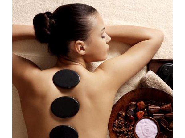 Woman receives stone massage at spa
