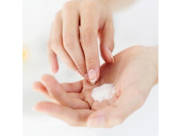 Woman applying cream to body