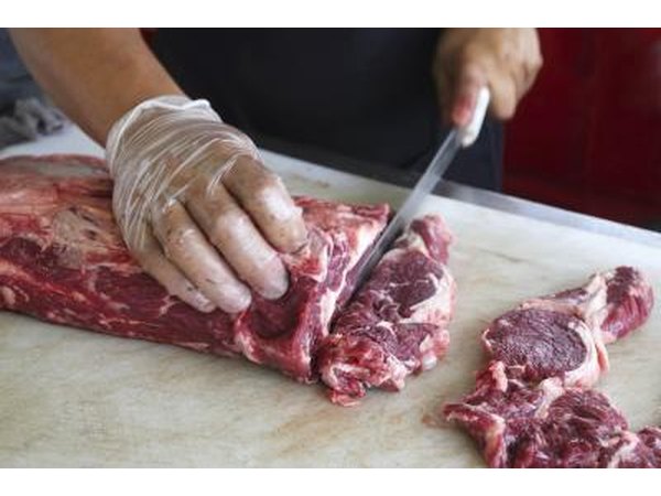 Deli worker cutting meat