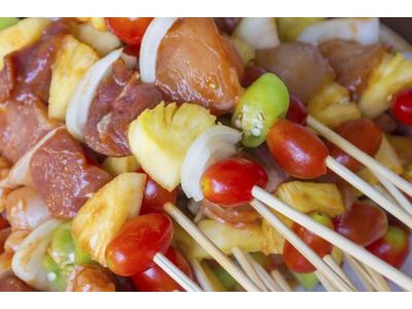 Prepared chicken sticks with pineapple, tomatoes and other vegetables.