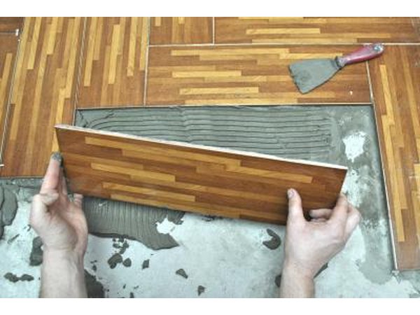 Laying tiles on floor.