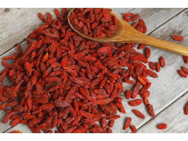 A heap of goji berries on a wooden surface