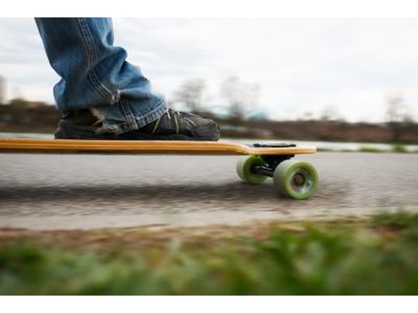 A close-up of a skater's foot on a longboard.