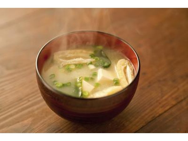 A steaming bowl of miso soup on the table.