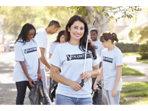 A woman and team volunteering to help clean the community.