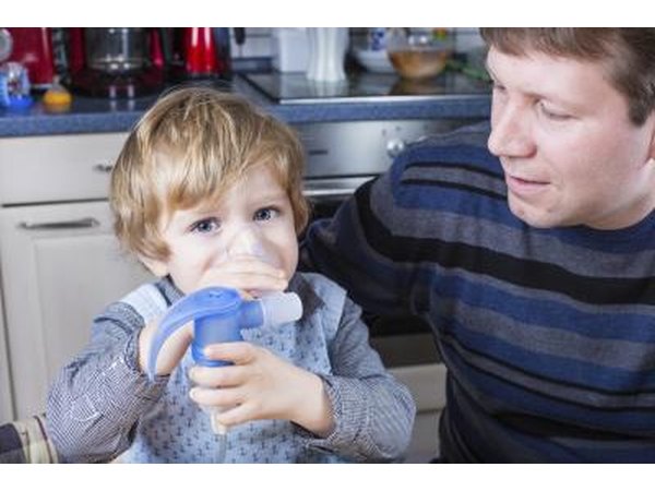 Little boy using nebulizer at home