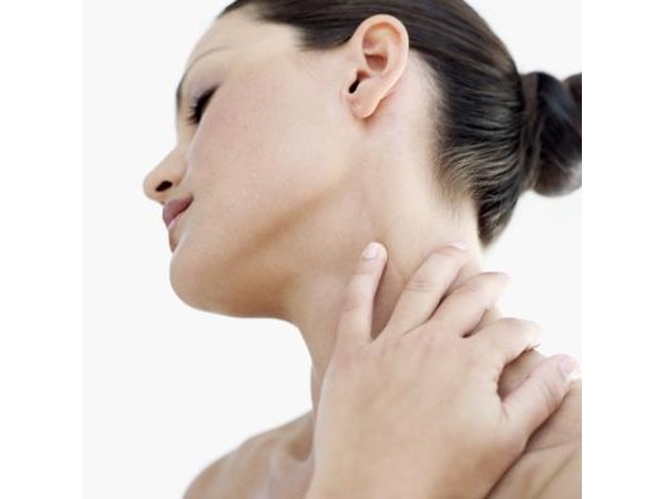 A woman holds her swollen neck.