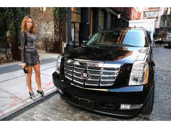 A woman standing next to an Escalade