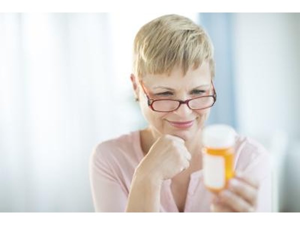 Woman reading prescription bottle.