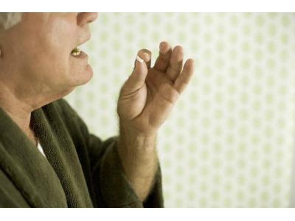 Man in housecoat taking pill