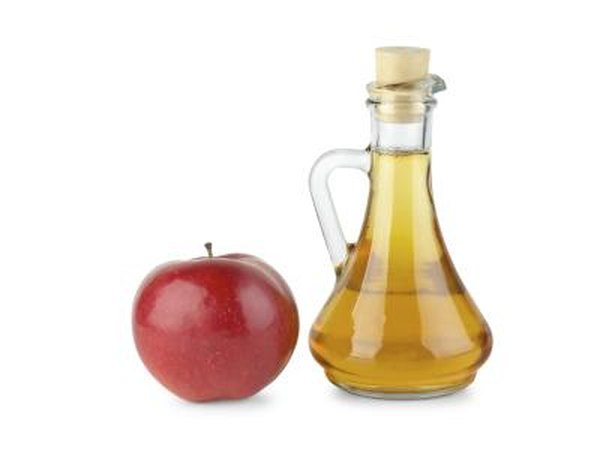 Decanter with vinegar and an apple on the side.