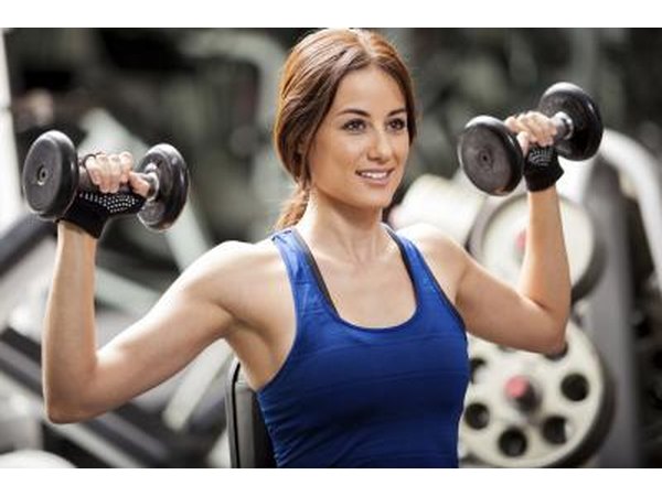 Woman lifting weights in gym.