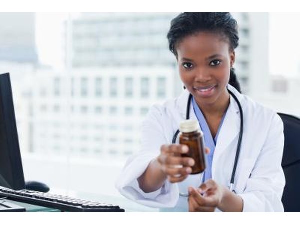 internal medicine doctor holding out prescription bottle