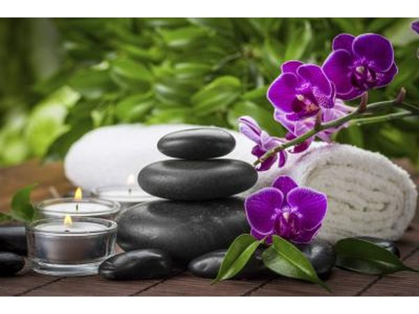 orchids beside candle and towel at beauty spa