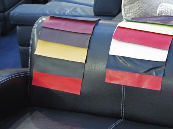 A leather couch in a furniture store with color swatches draped over the back.