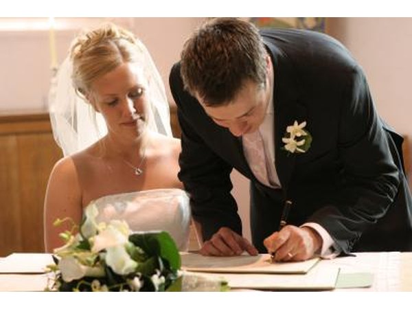 A newly wedded couple sign documents.