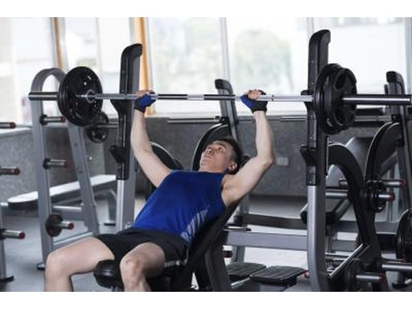 Man bench pressing weights in a gym