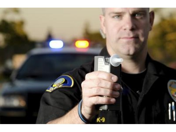 policeman holding up breathalyzer