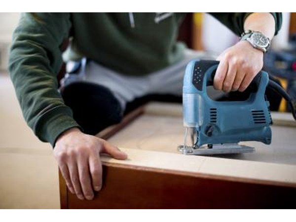 A worker saws custom cabinets.