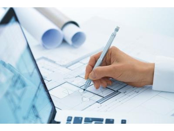 Close-up of a hand sketching an architectural drawing.