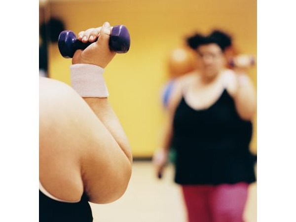 A woman does weight training at a gym.