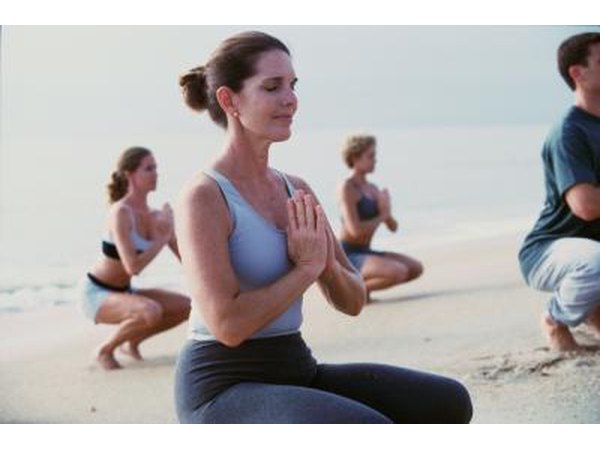 Young adults doing low squats on the beach