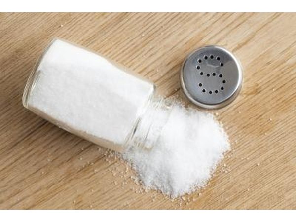 Table salt spills from open shaker