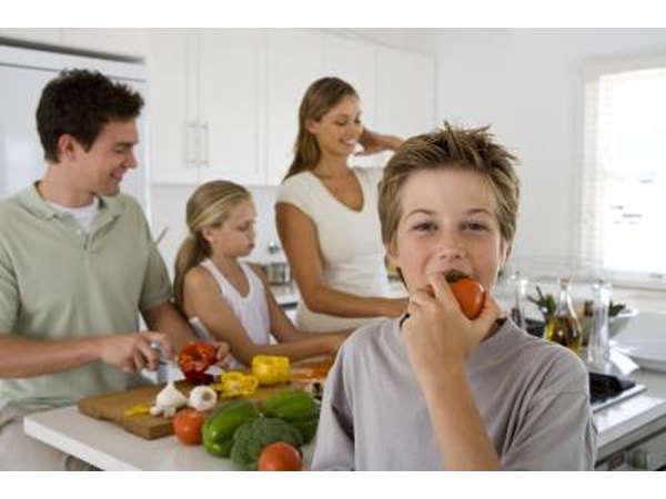 child biting into vegetable in kitchen