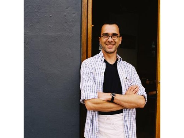 A server stands at the front door of an establishment.