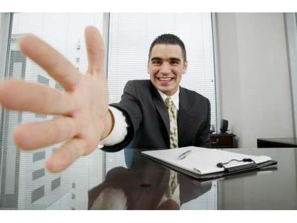 Close up of man dressed in a suit extending his hand for a handshake.