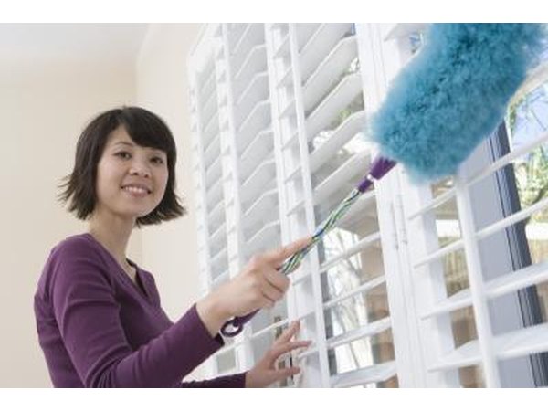 Woman dusting blinds
