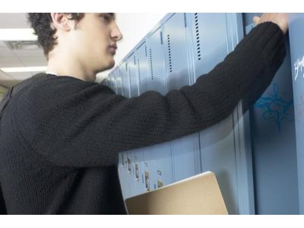 Teen boy opening locker