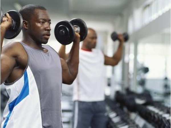 A man works out with dumbbells at the gym.