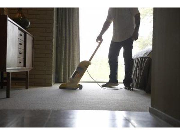 Man vacuuming bedroom