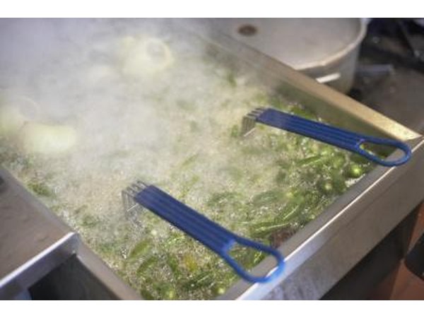 Green chilies being fried in oil cooker