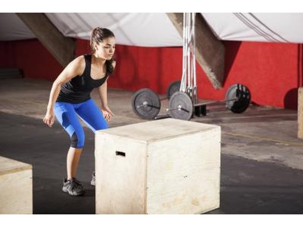 A young lady is doing box jumps.